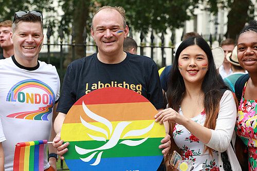 Ed Davey with fellow Liberal Democrats at pride holding a Lib Dem pride poster
